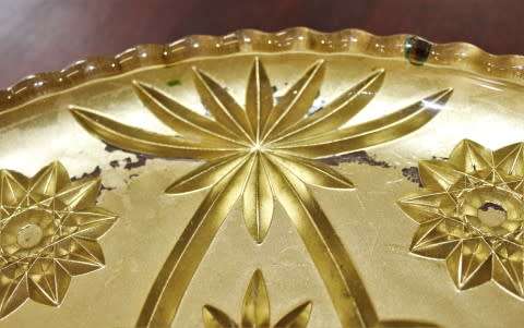 An eye-catching, round gold-coloured glass tray, with a beautiful pattern. Perfect on display!