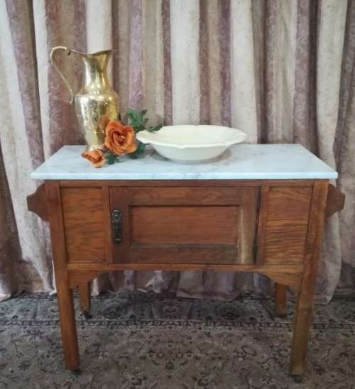A wonderful vintage solid Oak single door wash stand with a white marble top on castors - stunning!!