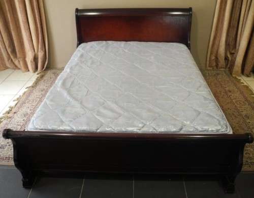 A stylish modern Coricraft Mahogany Queen sleigh bed with an Exotic pillow top mattress