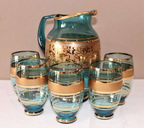 A unique set of matching cups with a jug decorated with gold gilt, perfect for entertaining guests.