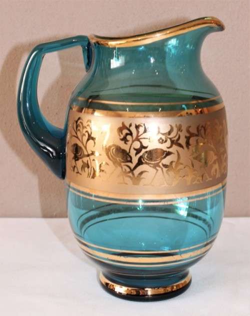 A unique set of matching cups with a jug decorated with gold gilt, perfect for entertaining guests.