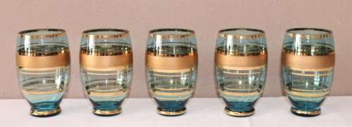 A unique set of matching cups with a jug decorated with gold gilt, perfect for entertaining guests.