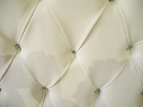 An exceptional oversized Queen wing back chair in durable white faux leather. Great "Feature" chair