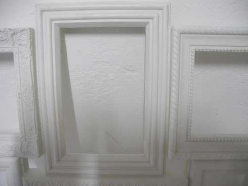 A stunning white plastic wall mounted photo frame for 8 photos. Lifespace Sale