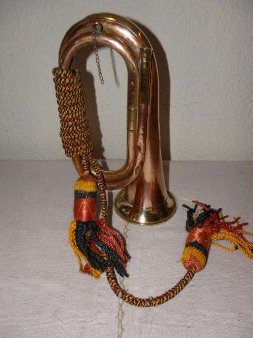 A STUNNING VINTAGE COPPER AND BRASS BUGLE WITH DECORATIVE CORD AROUND IT