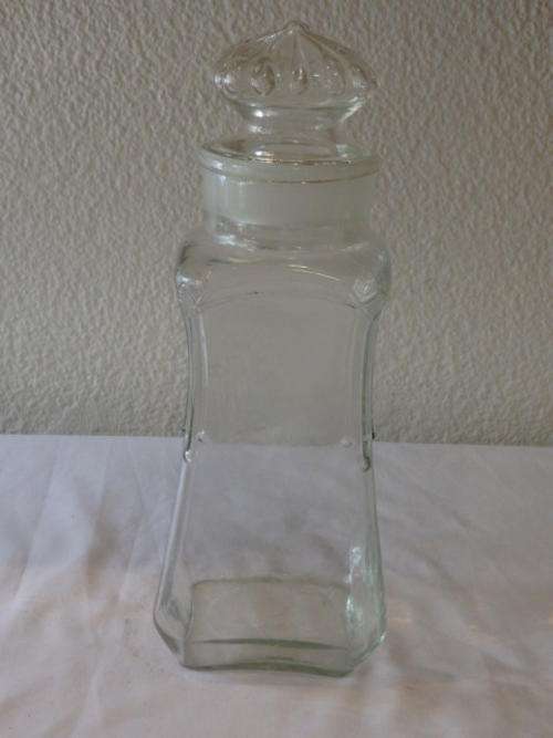 A VERY TALL GLASS JAR WITH BROAD GLASS STOPPER AND SANDBLASTED DETAILING AROUND THE NECK