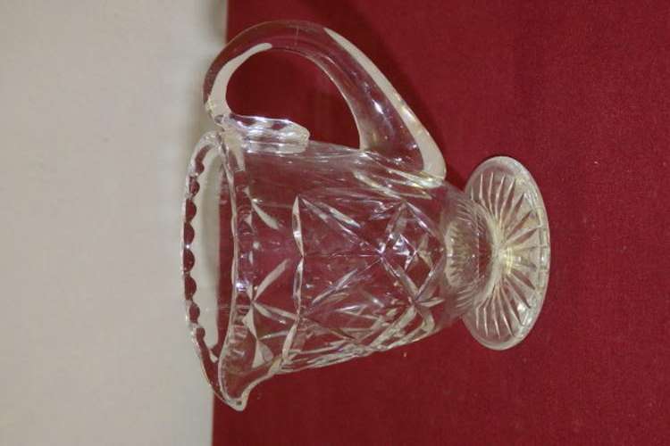 AN EXQUISITE CUT CRYSTAL MILK JUG WITH BEAUTIFUL DESIGN DETAILING AND HAND BLOWN HANDLE