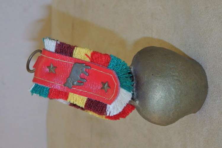 A GORGEOUS BRASS GOAT BELL WITH A COLOURFUL "RIBBON" AND THE ORIGINAL CLANGER