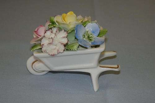 AN EXQUISITE VINTAGE ROYAL DOULTON HAND MADE AND PAINTED WHEELBARROW OF FLOWERS