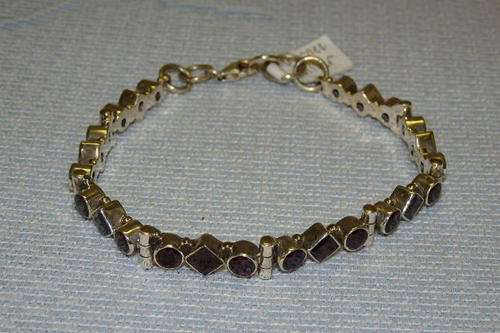 AN EXQUISITE STERLING SILVER LADIES GARNET BRACELET WITH A SERIES OF 24 SQUARE AND ROUND STONES
