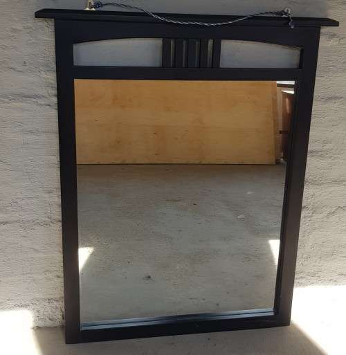 A vintage wall hanging mirror with a wood frame, great for above a basin or mantle