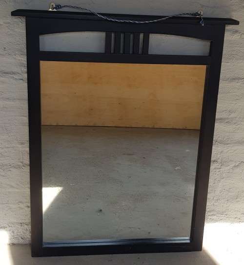 A vintage wall hanging mirror with a wood frame, great for above a basin or mantle