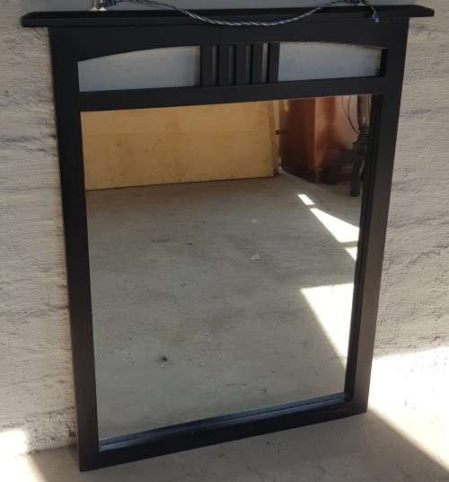 A vintage wall hanging mirror with a wood frame, great for above a basin or mantle