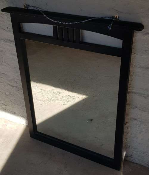 A vintage wall hanging mirror with a wood frame, great for above a basin or mantle