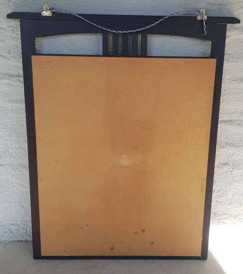 A vintage wall hanging mirror with a wood frame, great for above a basin or mantle