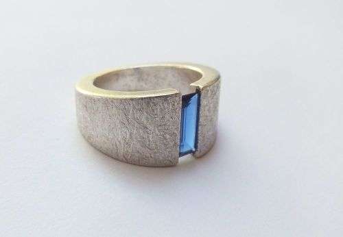 A thick heavy quality designer stamped sterling silver ring set with a faceted Sapphire