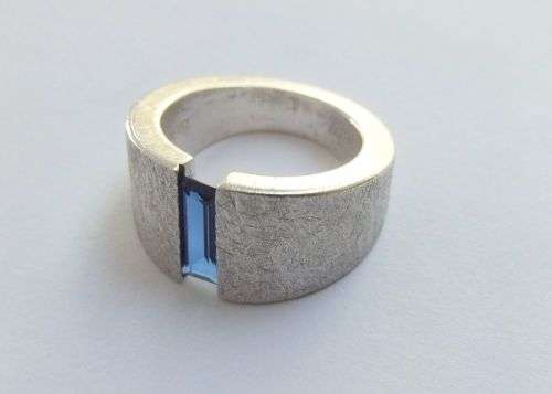 A thick heavy quality designer stamped sterling silver ring set with a faceted Sapphire