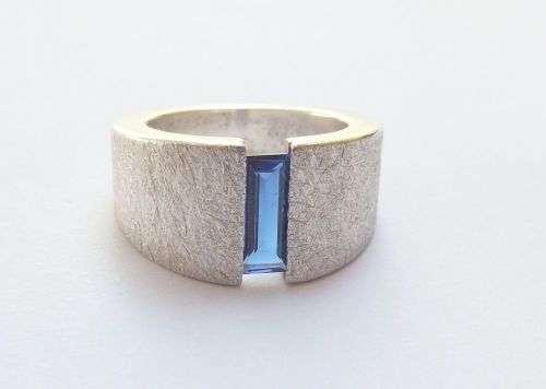 A thick heavy quality designer stamped sterling silver ring set with a faceted Sapphire