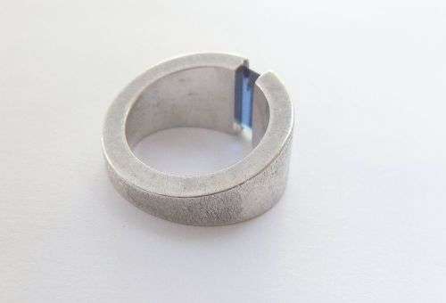 A thick heavy quality designer stamped sterling silver ring set with a faceted Sapphire