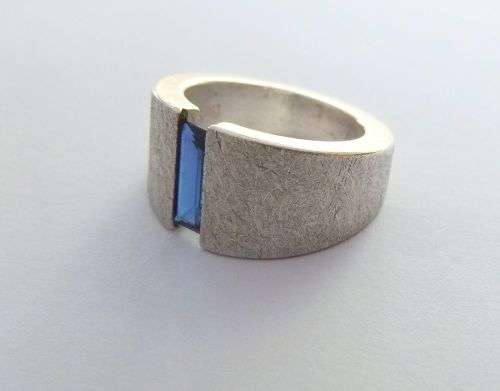 A thick heavy quality designer stamped sterling silver ring set with a faceted Sapphire