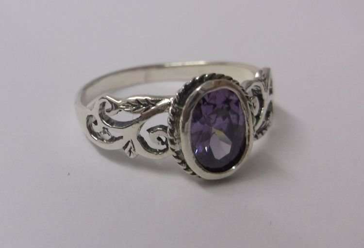 A FABULOUS SOLID STERLING SILVER RING WITH LOTS OF CURVES AND A FACETED PURPLE STONE