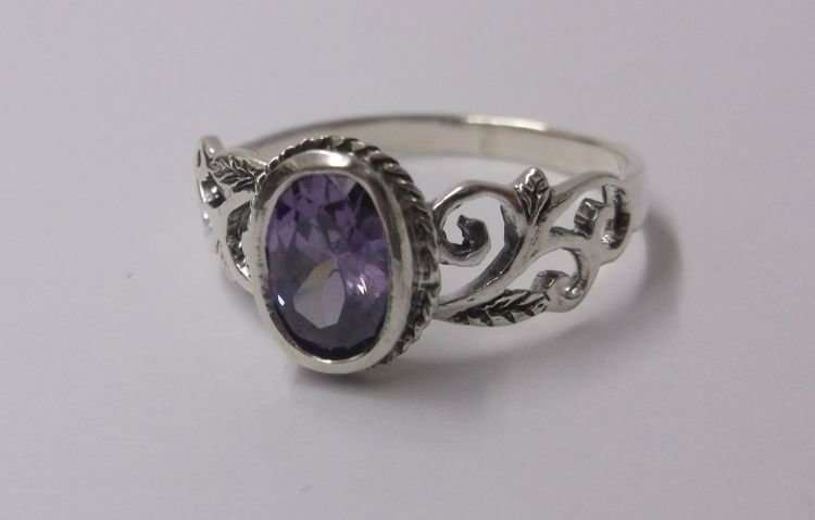 A FABULOUS SOLID STERLING SILVER RING WITH LOTS OF CURVES AND A FACETED PURPLE STONE