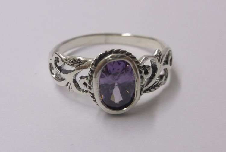 A FABULOUS SOLID STERLING SILVER RING WITH LOTS OF CURVES AND A FACETED PURPLE STONE