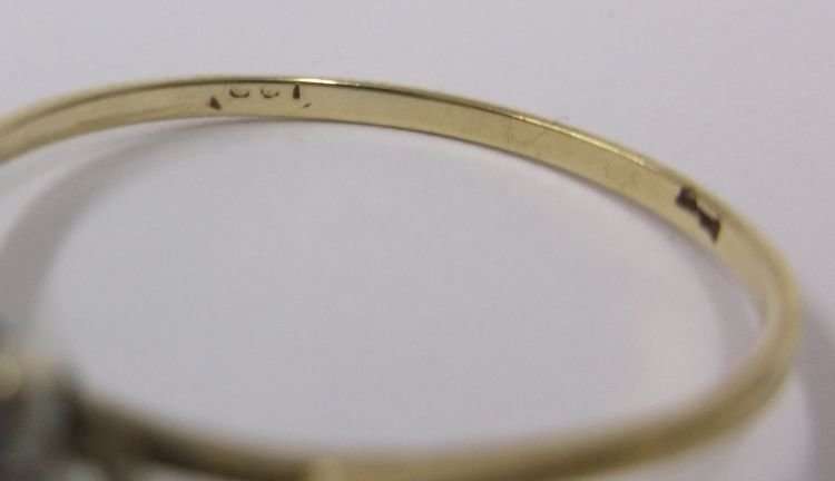 A PETITE AND CLASSIC CLUSTER LOOK RING IN 9 CT GOLD SET WITH A FACETED RED CENTER STONE