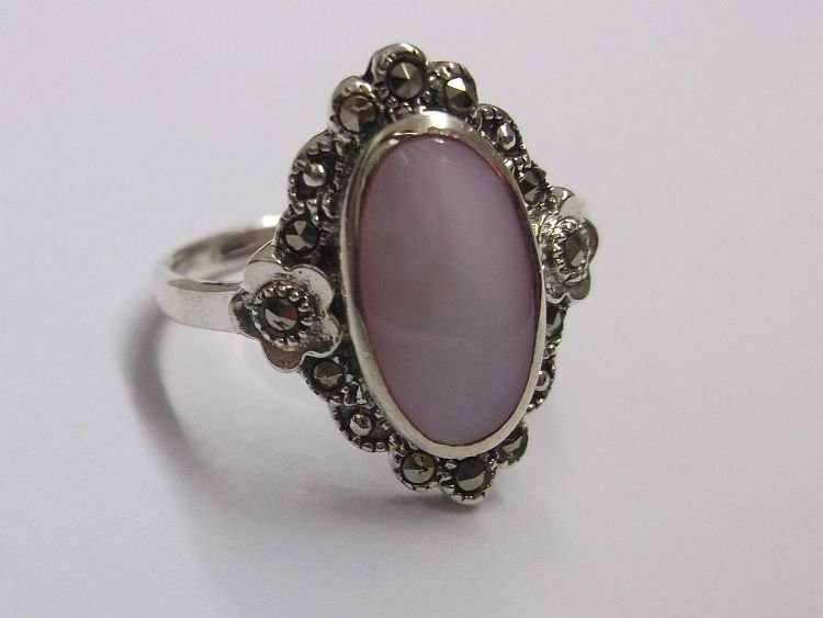 AN OUTSTANDING AND FANCY SOLID STERLING SILVER RING WITH MARCASITE AND A PINK INSET