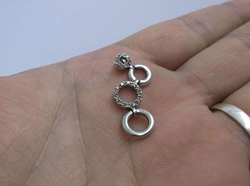 A VERY CLASSY SOLID 10 CT WHITE GOLD PENDANT SET WITH 18 TINY DIAMONDS PLUS STERLING SILVER NECKLACE