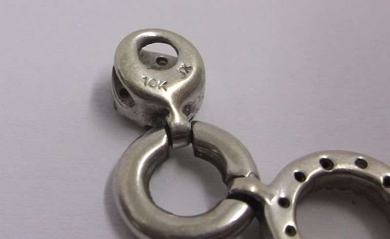 A VERY CLASSY SOLID 10 CT WHITE GOLD PENDANT SET WITH 18 TINY DIAMONDS PLUS STERLING SILVER NECKLACE