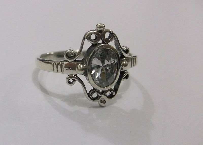 A SUPERB SOLID STERLING SILVER RING WITH FANCY DESIGN AND FACETED CLEAR STONE
