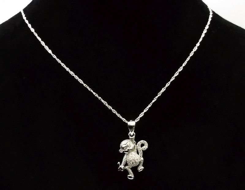 A CUTE STERLING SILVER MONKEY WITH BANANA PENDANT PLUS A 45 CM STERLING SILVER NECKLACE