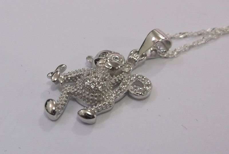 A CUTE STERLING SILVER MONKEY WITH BANANA PENDANT PLUS A 45 CM STERLING SILVER NECKLACE