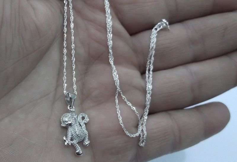 A CUTE STERLING SILVER MONKEY WITH BANANA PENDANT PLUS A 45 CM STERLING SILVER NECKLACE