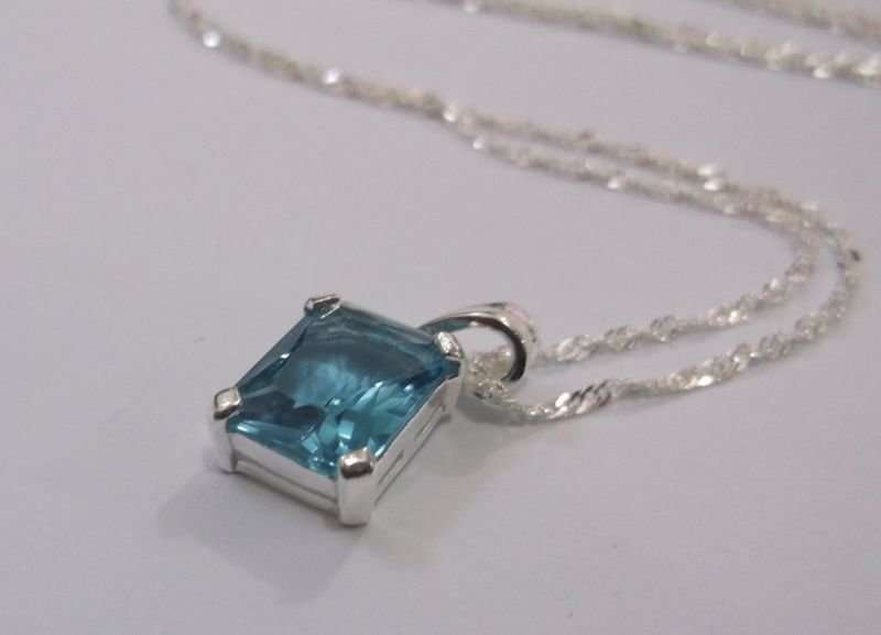 A STUNNING STERLING SILVER PENDANT WITH FACETED LIGHT BLUE STONE PLUS 45 CM STERLING SILVER NECKLACE