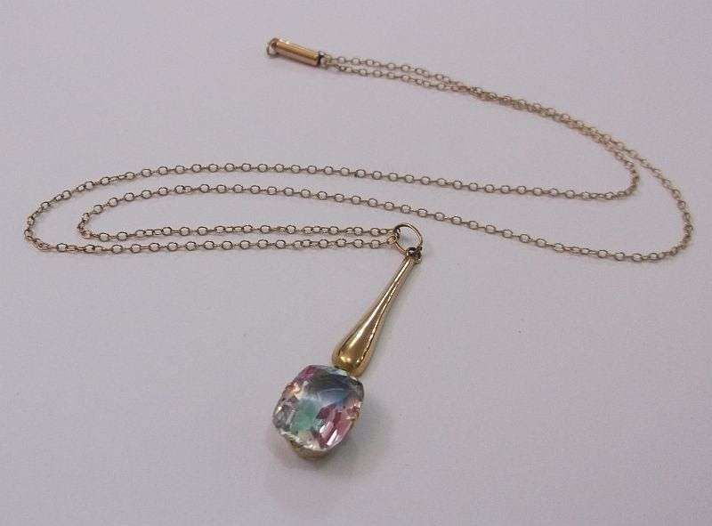 A STUNNING ANTIQUE 9 CARAT GOLD NECKLACE WITH TEAR SHAPED PENDANT AND FACETED RAINBOW LOOK STONE