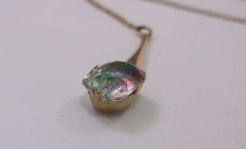 A STUNNING ANTIQUE 9 CARAT GOLD NECKLACE WITH TEAR SHAPED PENDANT AND FACETED RAINBOW LOOK STONE