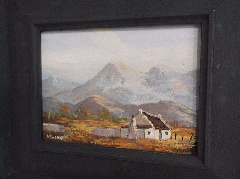 A LOVELY ORIGINAL OIL ON BOARD BY JUNE TUCKETT DEPICTING A HOMESTEAD SURROUNDED BY A MOUNTAIN RANGE