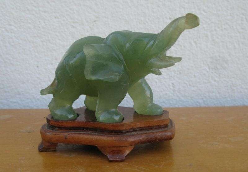 A BEAUTIFULLY CARVED JADE ELEPHANT ON A WOODEN PLINTH FROM THE 1930`S