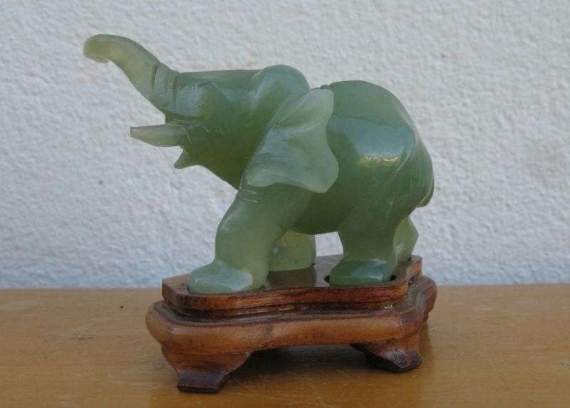 A BEAUTIFULLY CARVED JADE ELEPHANT ON A WOODEN PLINTH FROM THE 1930`S