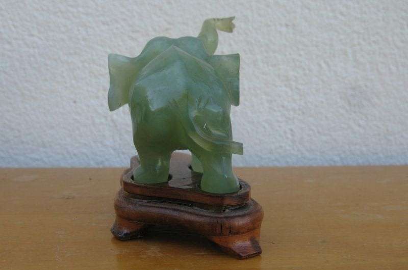 A BEAUTIFULLY CARVED JADE ELEPHANT ON A WOODEN PLINTH FROM THE 1930`S