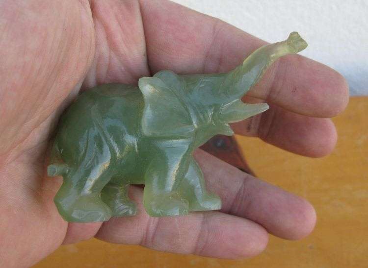 A BEAUTIFULLY CARVED JADE ELEPHANT ON A WOODEN PLINTH FROM THE 1930`S