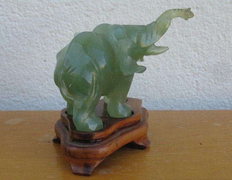 A BEAUTIFULLY CARVED JADE ELEPHANT ON A WOODEN PLINTH FROM THE 1930`S