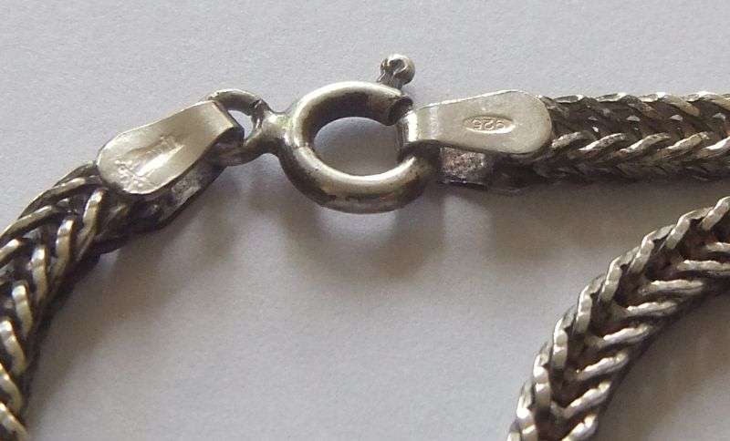 A STRONG AND STURDY "WEAVED" STERLING SILVER NECKLACE WITH A FACETED PURPLE STONE SET SILVER CROSS