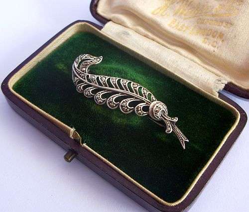 A VINTAGE FERN SHAPED SOLID SILVER BROOCH SET WITH MARCASITE