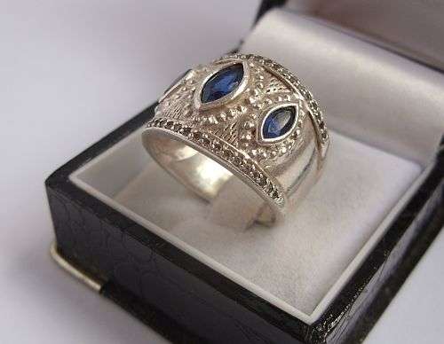 A WIDE SOLID STERLING SILVER RING SET WITH FACETED CZ STONES AND 3 MARQUISE CUT FACETED BLUE STONES