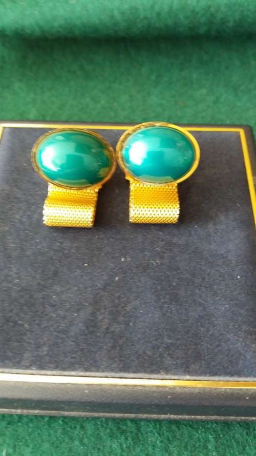 A Pair Of Cuff Links With Green Stones