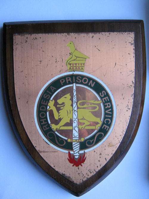 RHODESIAN PRISON SERVICES METAL CREST ON A WOODEN SHIELD - Worse for wear in places otherwise good