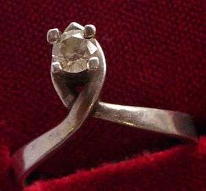 A PETITE STERLING SILVER RING SET WITH A SINGLE FACETED CZ